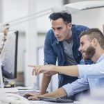 Industrial designers at the office discussing project on the computer